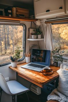 a laptop computer sitting on top of a wooden desk in front of a camper