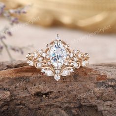 a close up of a ring on a piece of wood with flowers in the background