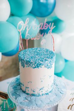 a blue and white birthday cake sitting on top of a table