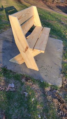 a wooden bench sitting on top of a cement slab