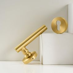 a golden door handle on top of a white box next to a gold keyhole