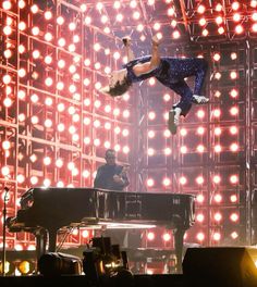 a man flying through the air while riding a skateboard on top of a stage