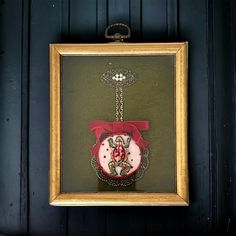 a frame hanging on the wall with a christmas ornament in it