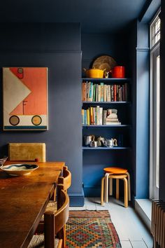 a dining room with blue walls and bookshelves