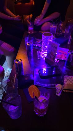 people sitting at a table with purple lighting