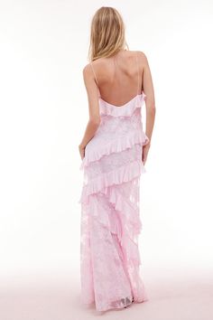 the back of a woman wearing a pink dress with ruffles and spaghetti straps