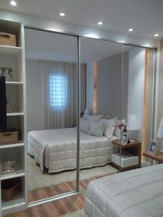 a bedroom with mirrored closet doors and two beds