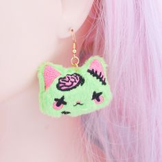 "Add a playful touch of spookiness to your style with our Plush Zombie Cat Earrings. These adorable and quirky earrings are crafted from soft and bright lime green minky fabric, making them a unique and eye-catching accessory. Hung elegantly on gold-colored earwires, these earrings are lightweight and comfortable to wear. Whether you're a fan of cute and spooky accessories or simply appreciate distinctive earrings, these plush zombie cat earrings are the perfect choice. They make a fun addition Kawaii Accessories Jewelry, Kawaii Accessories Earrings, Kawaii Halloween Accessories, Handmade Adjustable Kawaii Earrings, Spooky Accessories, Zombie Jewelry, Adjustable Kawaii Dangle Earrings, Kawaii Pink Dangle Earrings, Movie Gifts