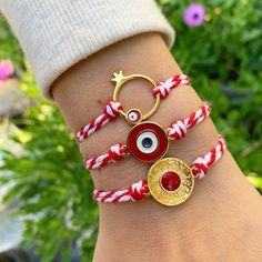 March Bracelets by Irene Andrea Jewelry *Well let's see Evil Eye's symbolism!  In many cultures, the evil eye is regarded as a symbol of Protection from the negative energy, while it attracts positivity! These bracelets, made of red and white cord, are called ''Martis''! In Greece we wear them from the beginning  to the end of March, as the tradition is that they are protecting us, so we will not get burned by the early spring sun of March! But off course, you can wear it also after March! If yo Symbolic Handmade Bracelets For Friendship, Symbolic Handmade Friendship Bracelets, Symbolic Friendship Bracelets, Symbolic Evil Eye Bracelet As Gift, Handmade Symbolic Charm Bracelet For Friendship, Handmade Symbolic Braided Bracelets As Gift, Friendship Bracelets With Charms, March Bracelet, Bracelets Evil Eye