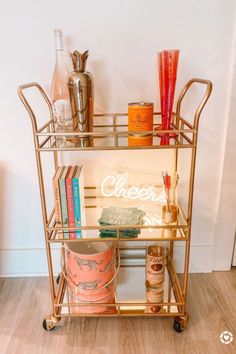 a gold bar cart with drinks on it