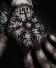 a person's hand with tattoos on it