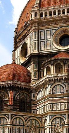 an ornate building with a clock on it's face and two arches at the top