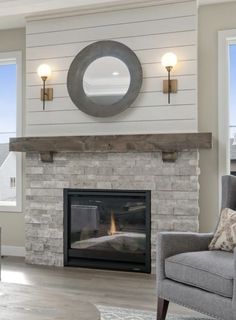 a living room with a couch, chair and fire place in front of a window