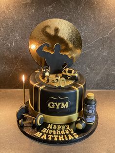 a black and gold birthday cake with an image of a man holding a golden trophy