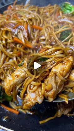 chicken lo mein noodles with broccoli and carrots in a wok