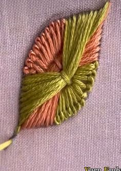 a close up of a piece of cloth with yarn on it and a needle in the middle