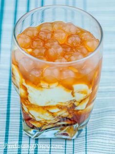 a glass filled with food sitting on top of a blue and white striped table cloth