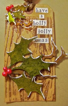 a piece of wood with holly on it and some words hanging from the side of it