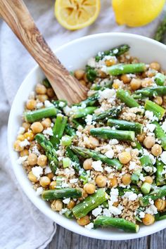 a white bowl filled with asparagus, chickpeas and feta cheese