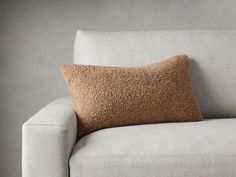 a white couch with a brown pillow on it