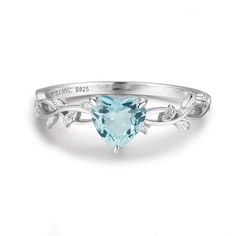 a heart shaped aqua blue topazte ring with leaves on the band and engraving