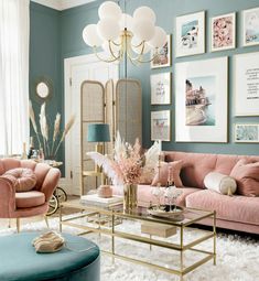 a living room filled with pink couches and chairs next to a coffee table in front of pictures on the wall