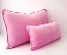 two pink pillows sitting next to each other