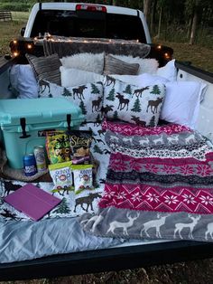 a bed in the back of a pick up truck with pillows and blankets on it