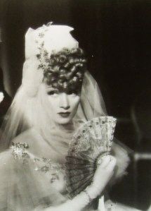 an old black and white photo of a bride holding a fan