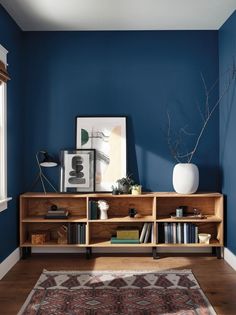 a living room with blue walls and a rug on the floor in front of it