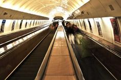 people are riding on an escalator in the subway