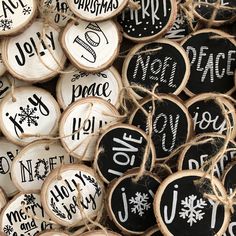 christmas wood slices with hand painted words and snowflakes are piled on top of each other