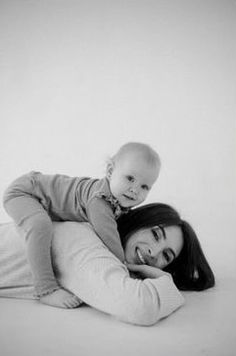 a woman laying on top of a bed holding a baby