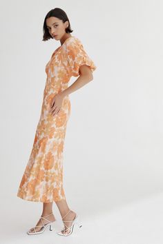 Perfect for everyday styling, the Elena Dress is perfect for layering on cooler days. Accentuated sleeves, high neckline, and back bodice cut out. A center-back split has been added for fluidity - pair with a simple slide for a relaxed look at garden party soirees, long lunches, or winery getaways. As seen on @georgiaoneil and @oceanellie_. - Round neck. - Accentuated puffed sleeves. - Elasticated sleeve opening. - Open back feature. - Back button closure. - Center back skirt split for fluidity. Spring Dresses In Rayon With Bias Cut, Spring Rayon Dresses With Bias Cut, Spring Brunch Dresses With Side Slits, Spring Rayon Bias Cut Dresses, Spring Bias Cut Rayon Dresses, Spring Rayon Maxi Dress With Bias Cut, Spring Bias Cut Rayon Maxi Dress, Spring Daywear Dresses With Side Slits, Spring Brunch Dress With Bias Cut