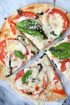 four slices of pizza with basil, tomatoes and mozzarella