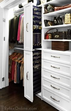 an organized closet with white cabinets and drawers