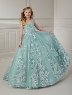 Your sweet girl will make a grand entrance in this beaded floral applique long sleeveless dress with A-line tulle skirt by Tiffany Princess 13720. This sleeveless gown features a scoop neck bodice with beaded floral lace appliques, A-line glitter tulle skirt, sweep train, and a lace-up back. House of Wu Tiffany Princess Collection Fall 2023 Style Number: 13720 Fabric: Beaded Floral Appliques/Tulle Please note: There may be a loss of glitter while wearing this dress due to the nature of the fabri Sleeveless Pageant Dress With Sheer Bodice, Pageant Dress With Floral Applique And Fitted Bodice, Pageant Gown With Fitted Bodice And Tulle Skirt, Princess-style Sleeveless Embellished Gown, Princess Style Sleeveless Embellished Gown, Princess Style Sleeveless Pageant Dress With Fitted Bodice, Embellished Sleeveless Tulle Gown, Sleeveless Embellished Pageant Gown, Sleeveless Floral Applique Ball Gown For Pageants