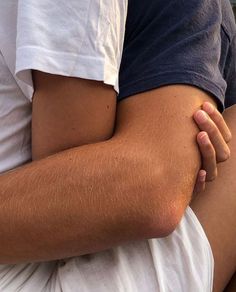 a close up of a person's legs with their arm wrapped around another persons leg