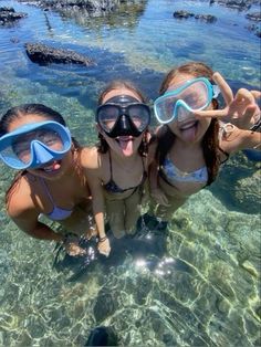 three girls wearing goggles and snorkels in the water