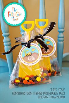 two bags with candy on them sitting in front of blue chairs and the words, construction themed printable tags instant instant