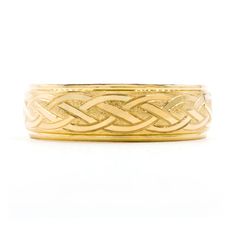 a gold wedding band with an intricate design