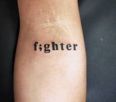 a person with a tattoo on their arm that says fighter in cursive font