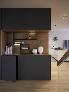 a modern kitchen with black cabinets and wood flooring