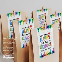 small brown paper bags with happy back to school tags hanging from clothes pins on them