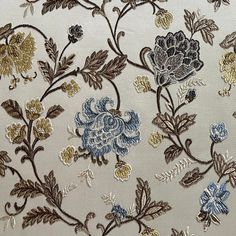 an embroidered fabric with blue and gold flowers on white background, close - up photo