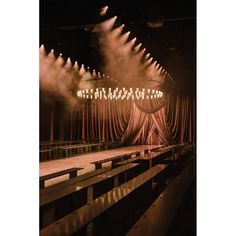 an empty stage with lots of lights and drapes on the curtained area in front of it