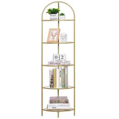 a gold metal shelf with books on top and plants in the bottom corner, against a white background