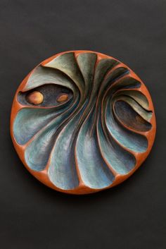 an orange and blue plate on a black surface