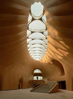 the inside of a building with stairs leading up to an open skylight above it