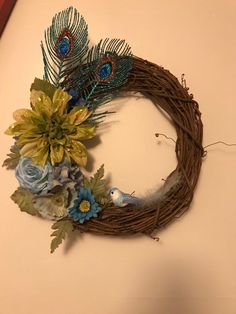 a wreath decorated with flowers and feathers